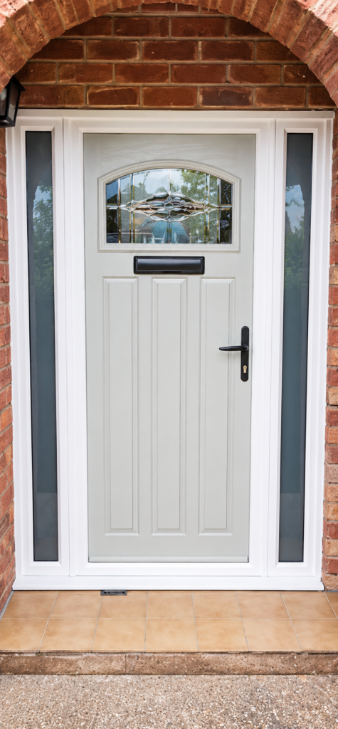 White front entrance door with a rectangular glazed panel, letterbox and matching glazed side panels set in a red-brick property.